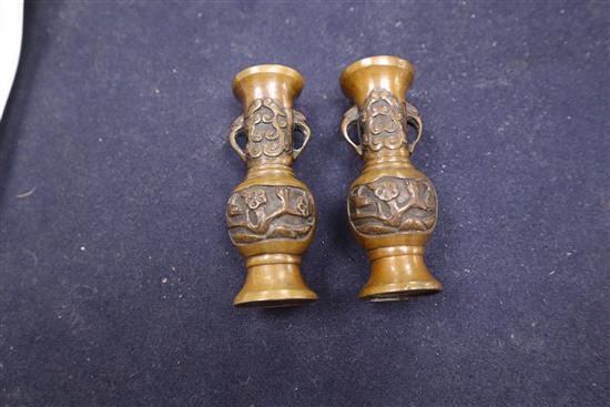 A Chinese bronze bell, a pair of miniature bronze vases and a blue and white cup with Kangxi mark tallest 15cm